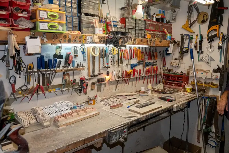 An ordered workshop wall with hand tools and supplies on it.