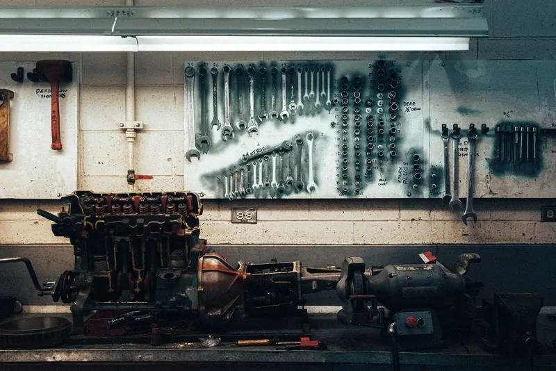 A row of wrenches hanging on a board on a workshop wall.